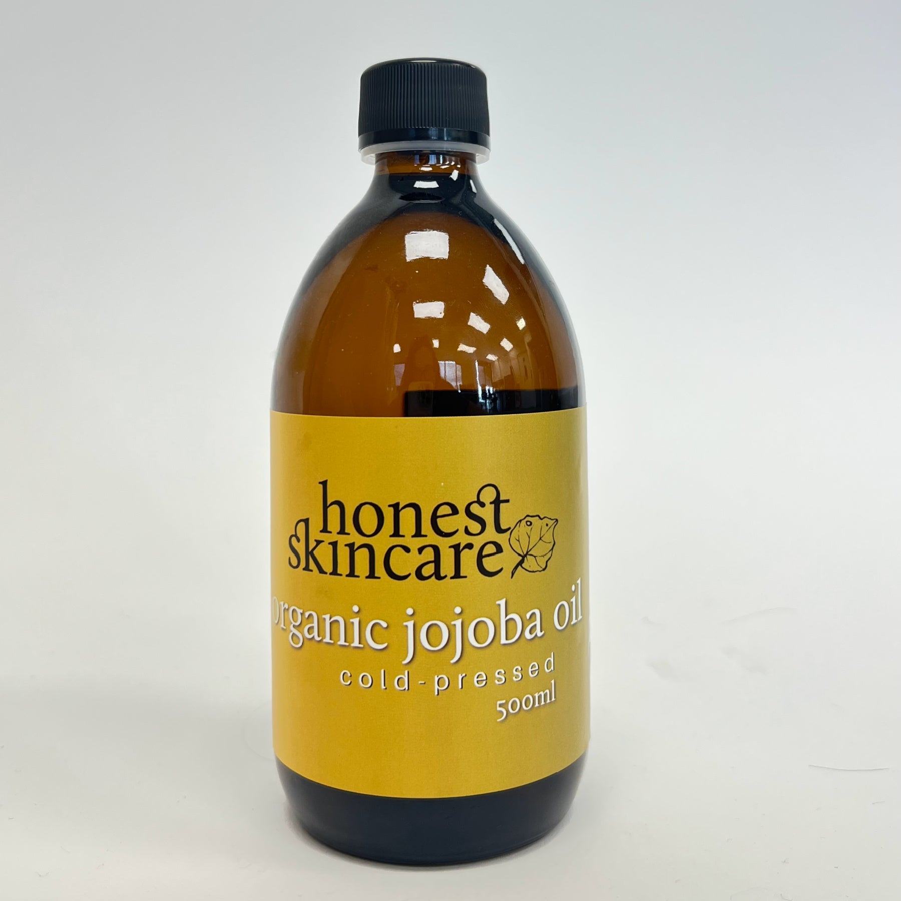 Bottle of honest skincare organic jojoba oil 500ml on a white background