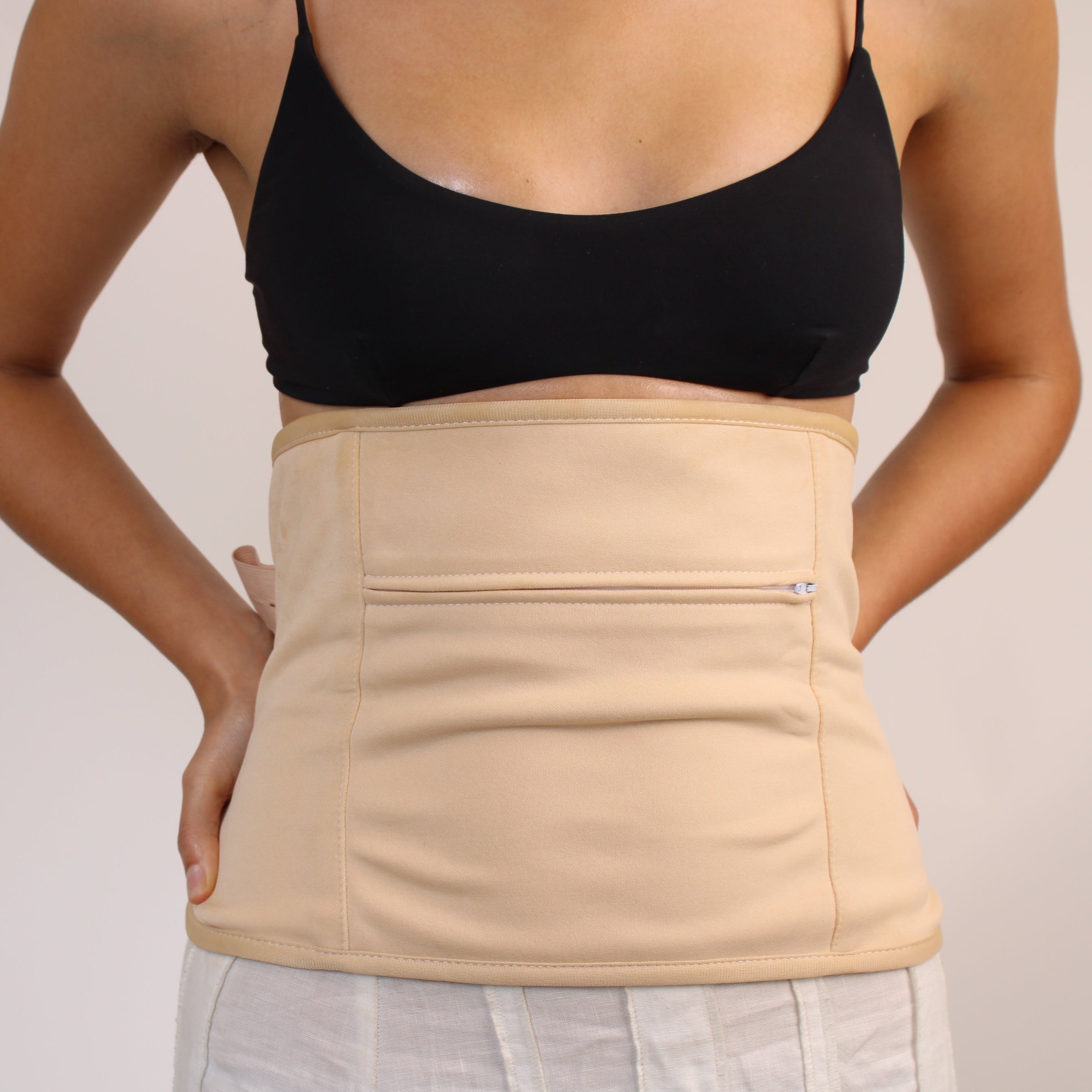 Person wearing a beige honest skincare waist wrap against a plain background