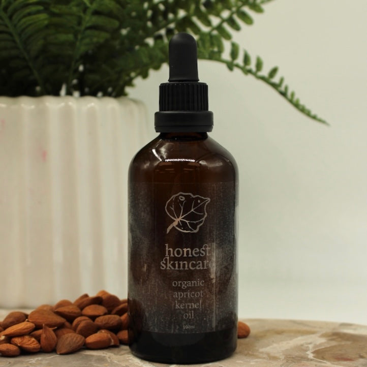 Bottle with Dropper of 100ml Organic Apricot Kernel Oil Plant in Background