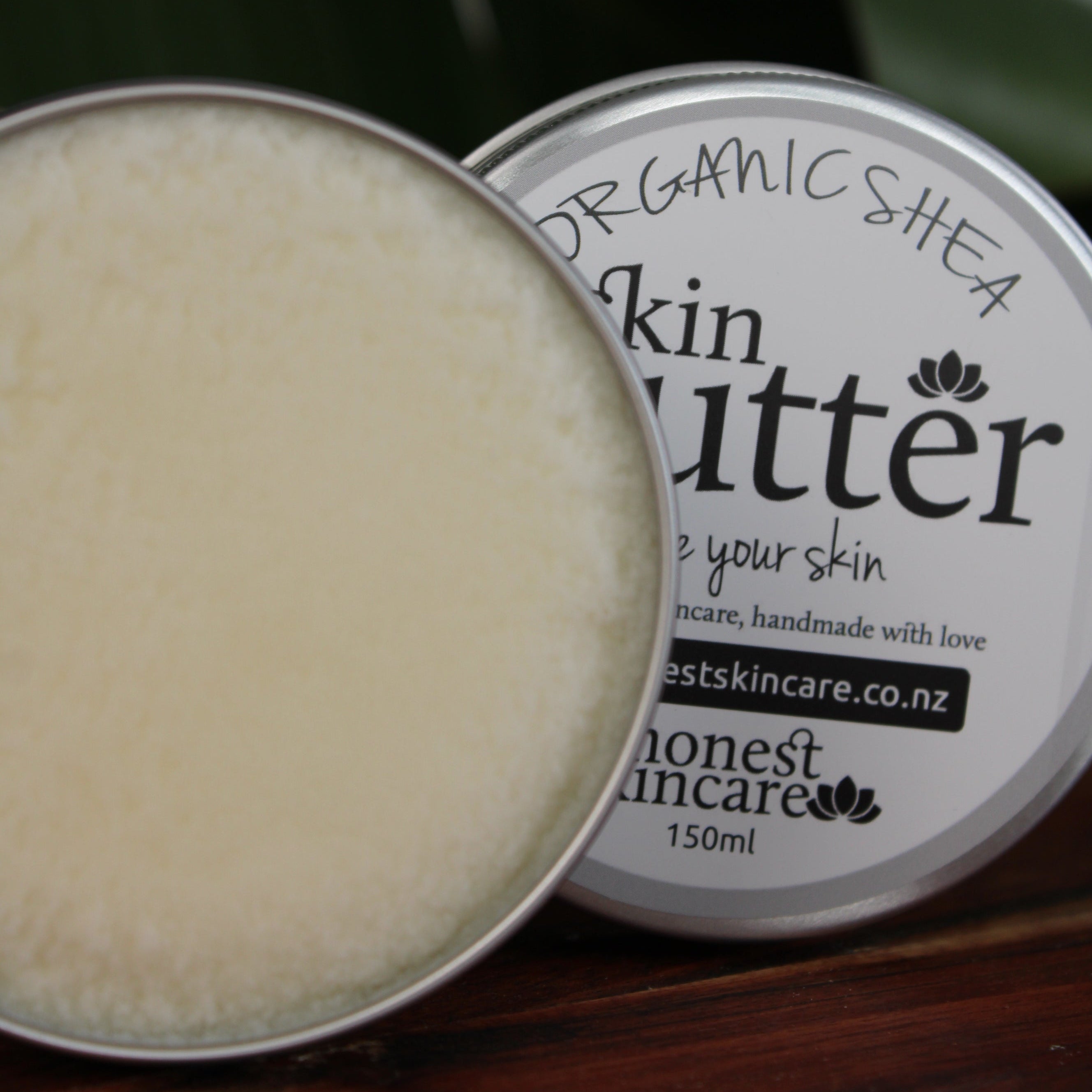 organic shea butter tin honest skincare with visible branding on a wooden surface