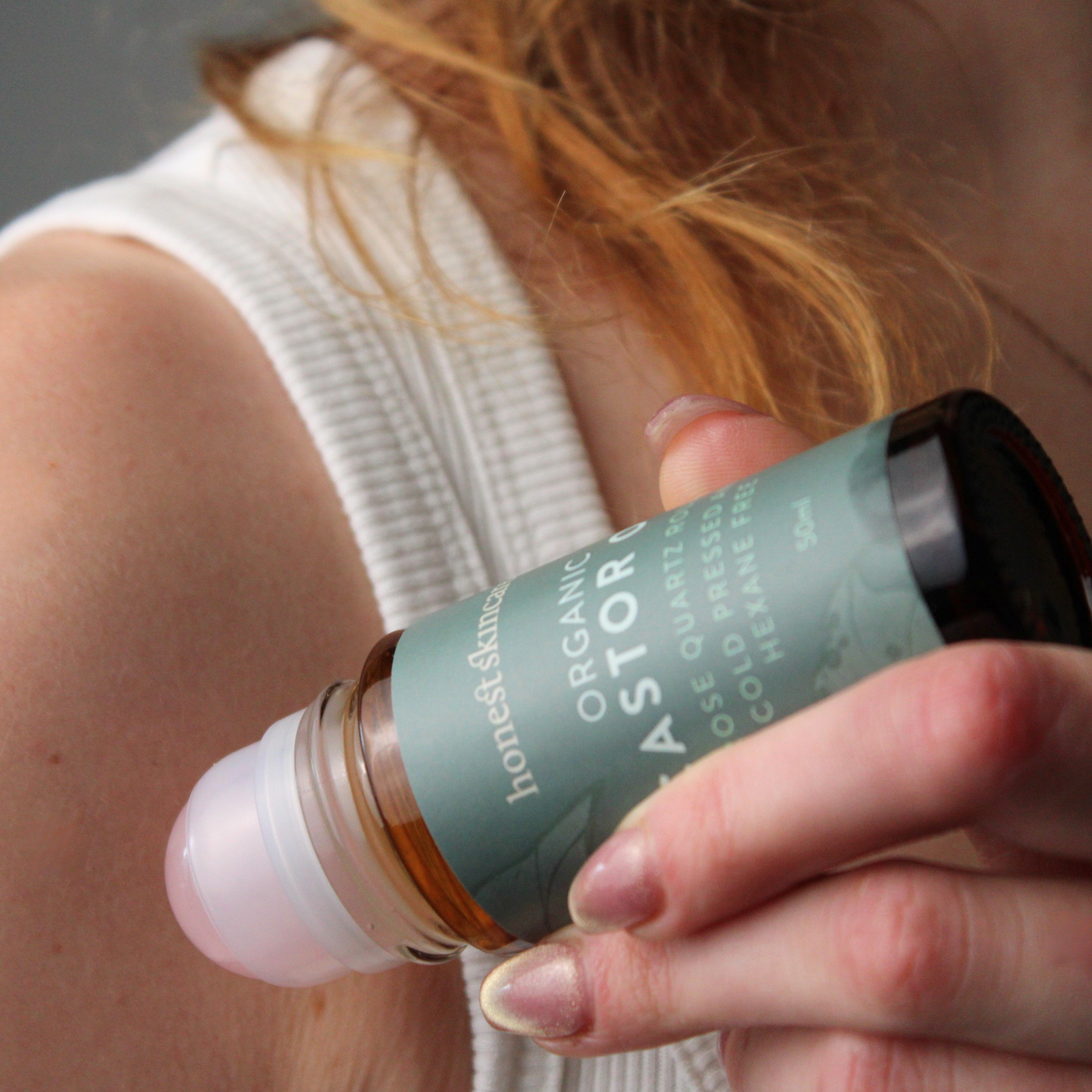 Hand holding a bottle labeled 'honest & clear' with a blurred background