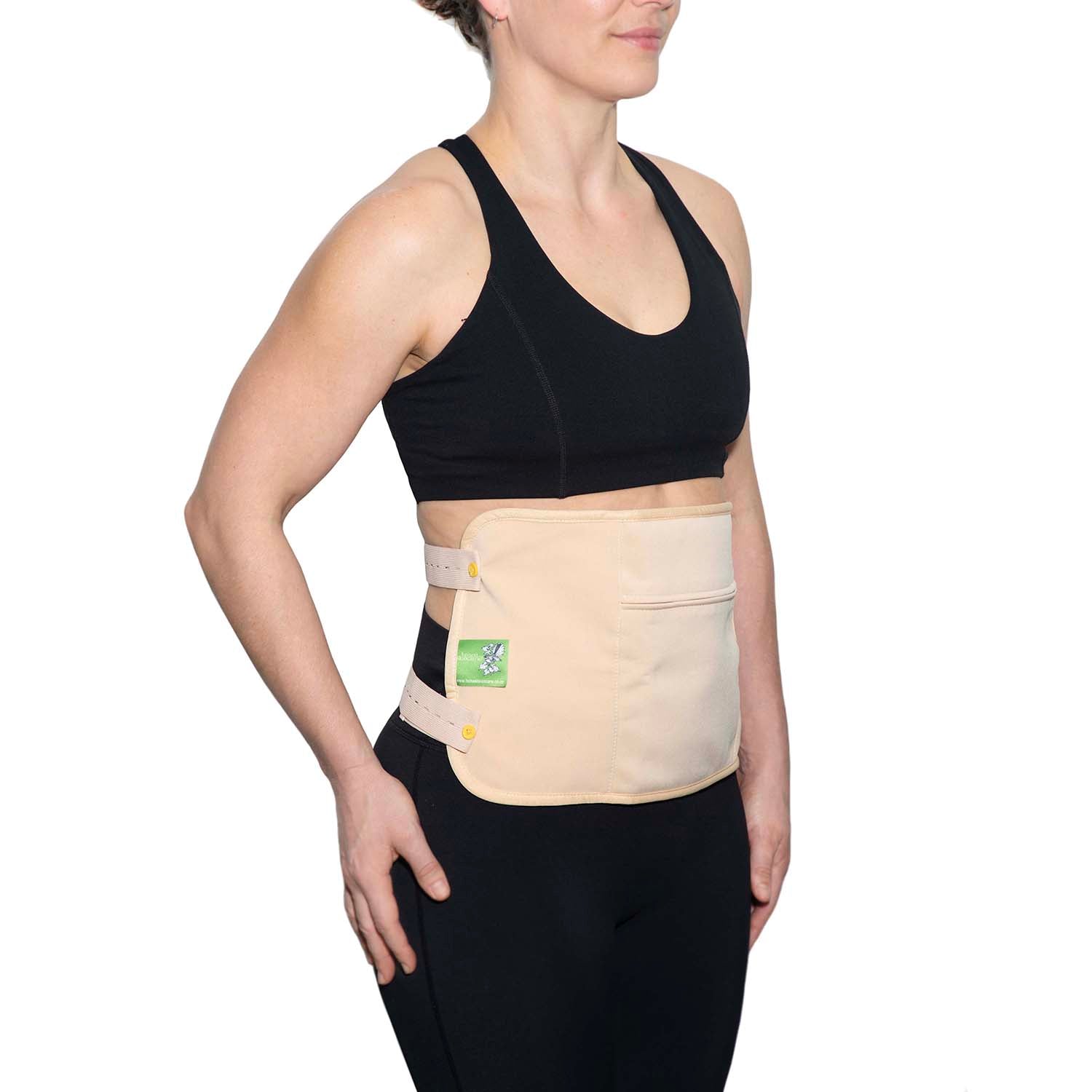 Woman wearing Castor Oil Pack wrap on her abdomen, showcasing the convenience of castor oil wraps for wellness.