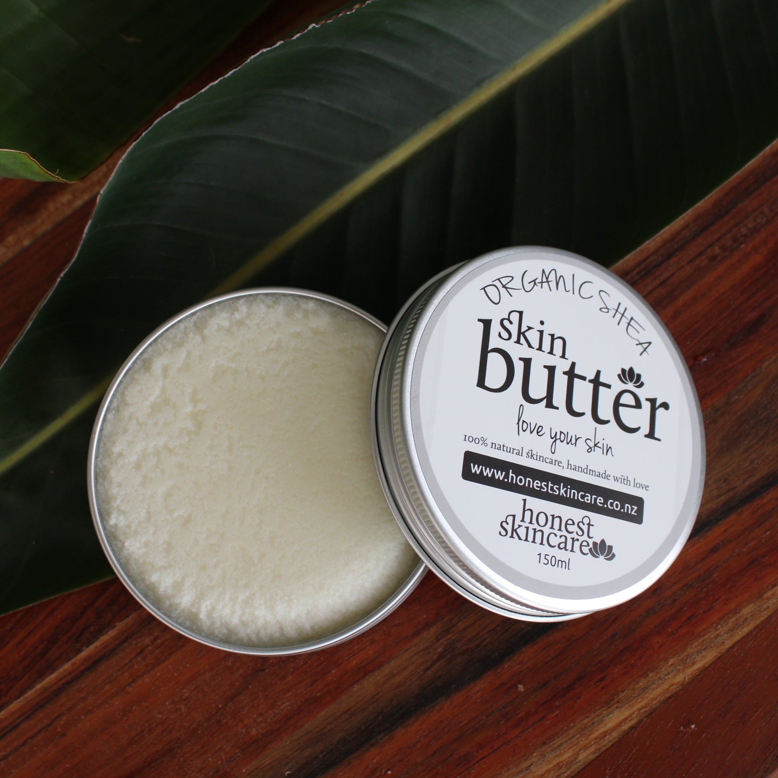 organic shea butter tin 150 ml honest skincare in a tin with a visible brand label on a wooden surface.