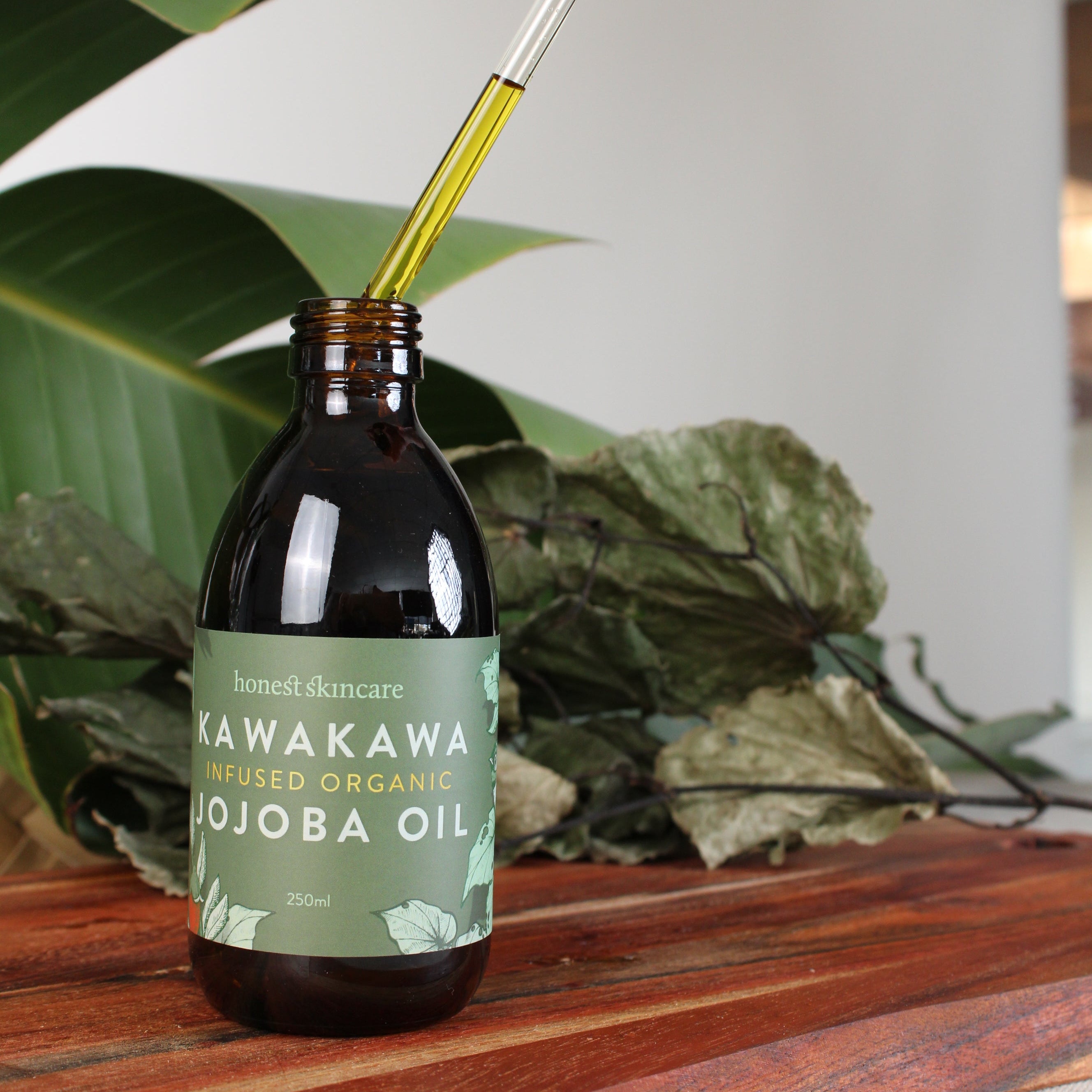 Bottle of Kawakawa Pureed Organic Oil being used on a plant