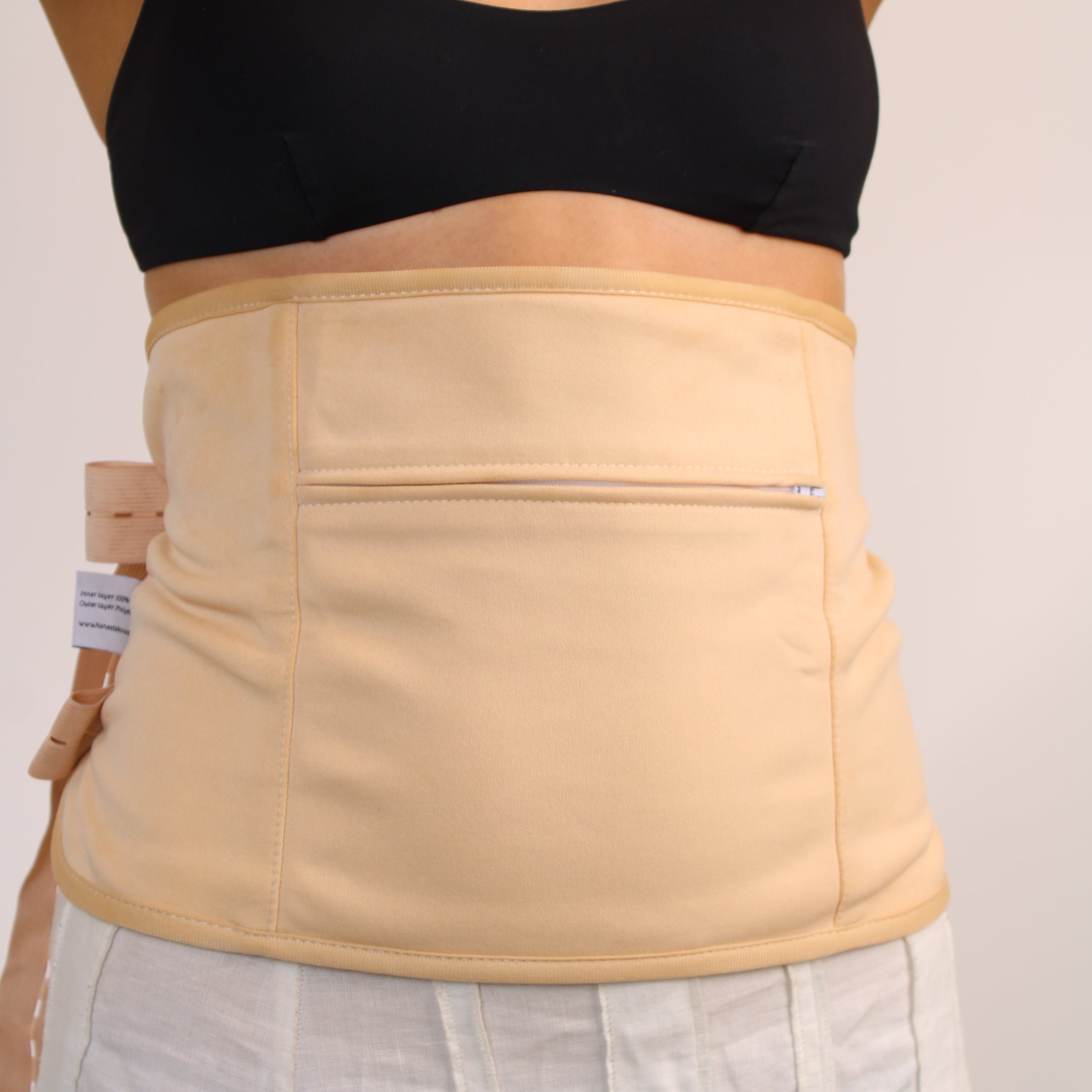 Person wearing a honest skincare beige waist wrap with a plain background
