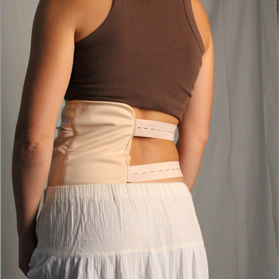 Person wearing a brown tank top and beige waist trainer against a plain background