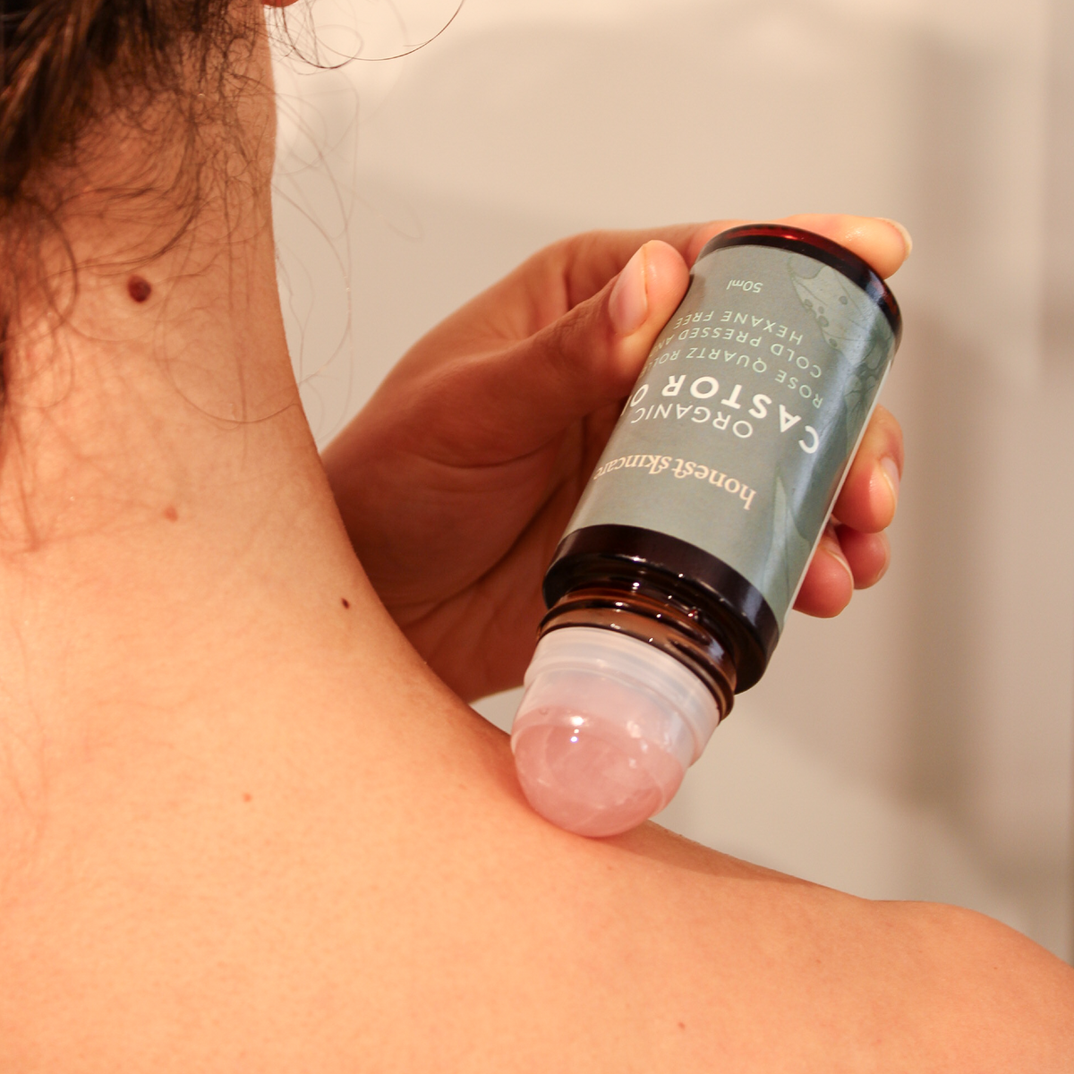 Rose Quartz Roller with Certified Organic Castor Oil back application 