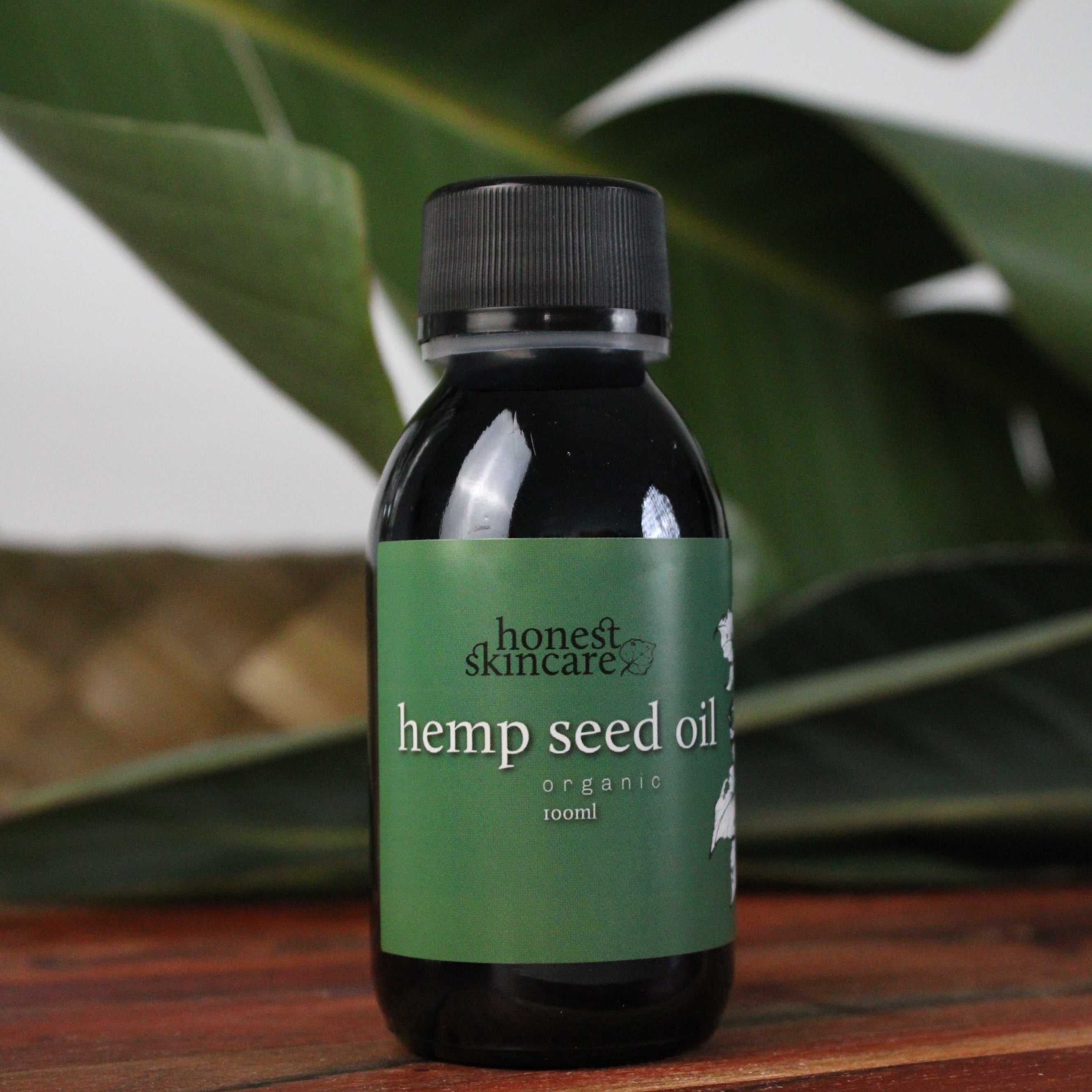 Bottle of honest skincare hemp seed oil on a leafy background