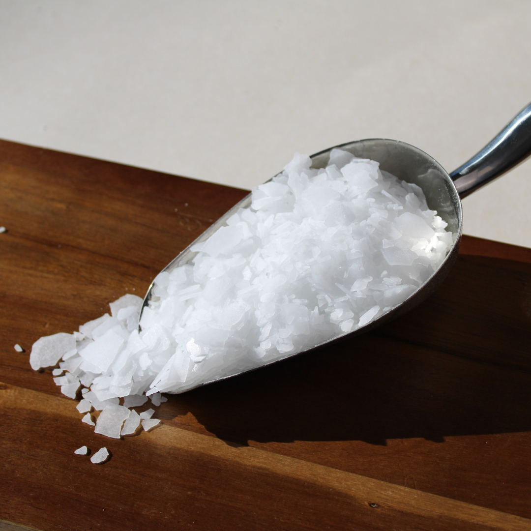 Spoonful of Honest Skincare magnesium flakes 250g on a wooden surface