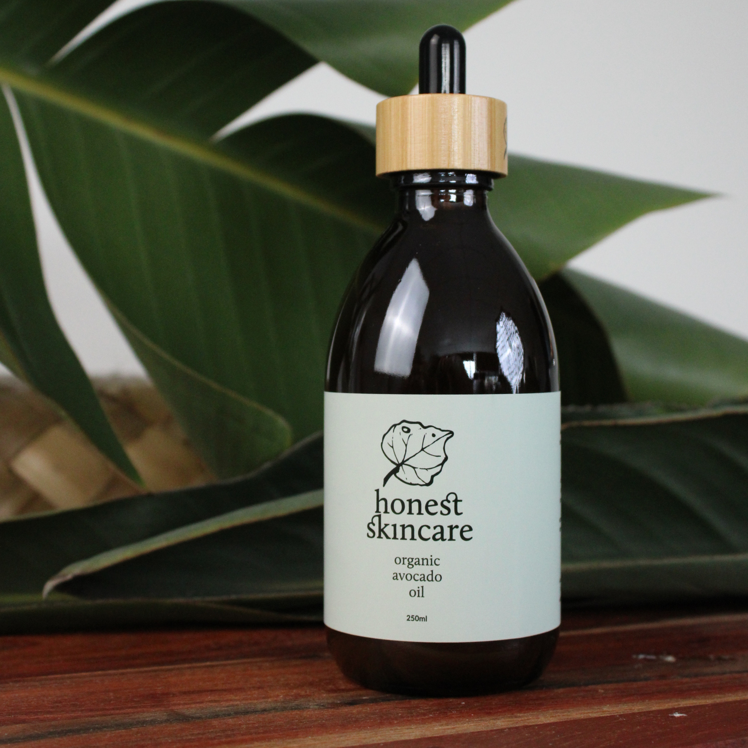 honest skincare organic avocado oil with dropper on set with green leaf