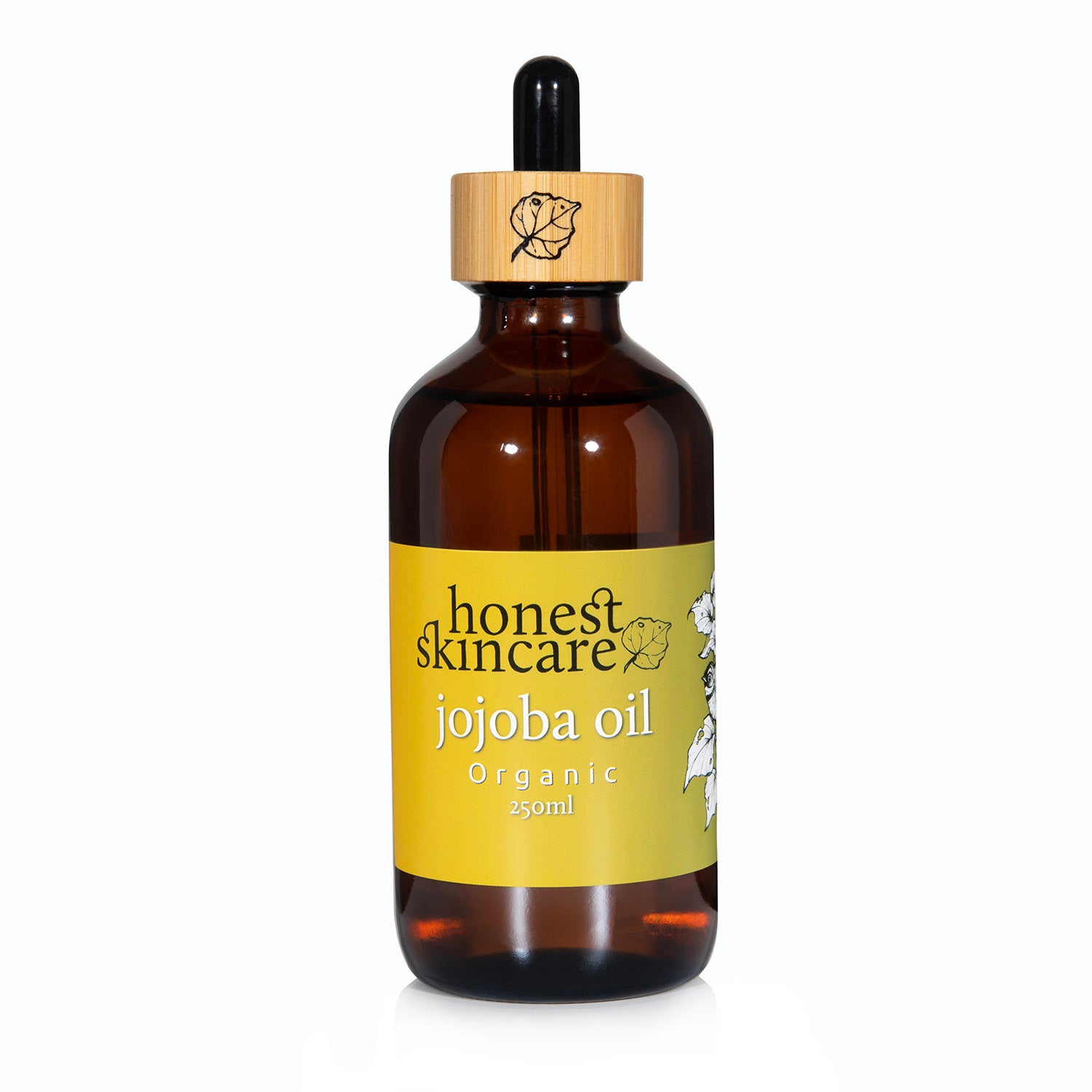 Bottle of honest skincare jojoba oil on a white background